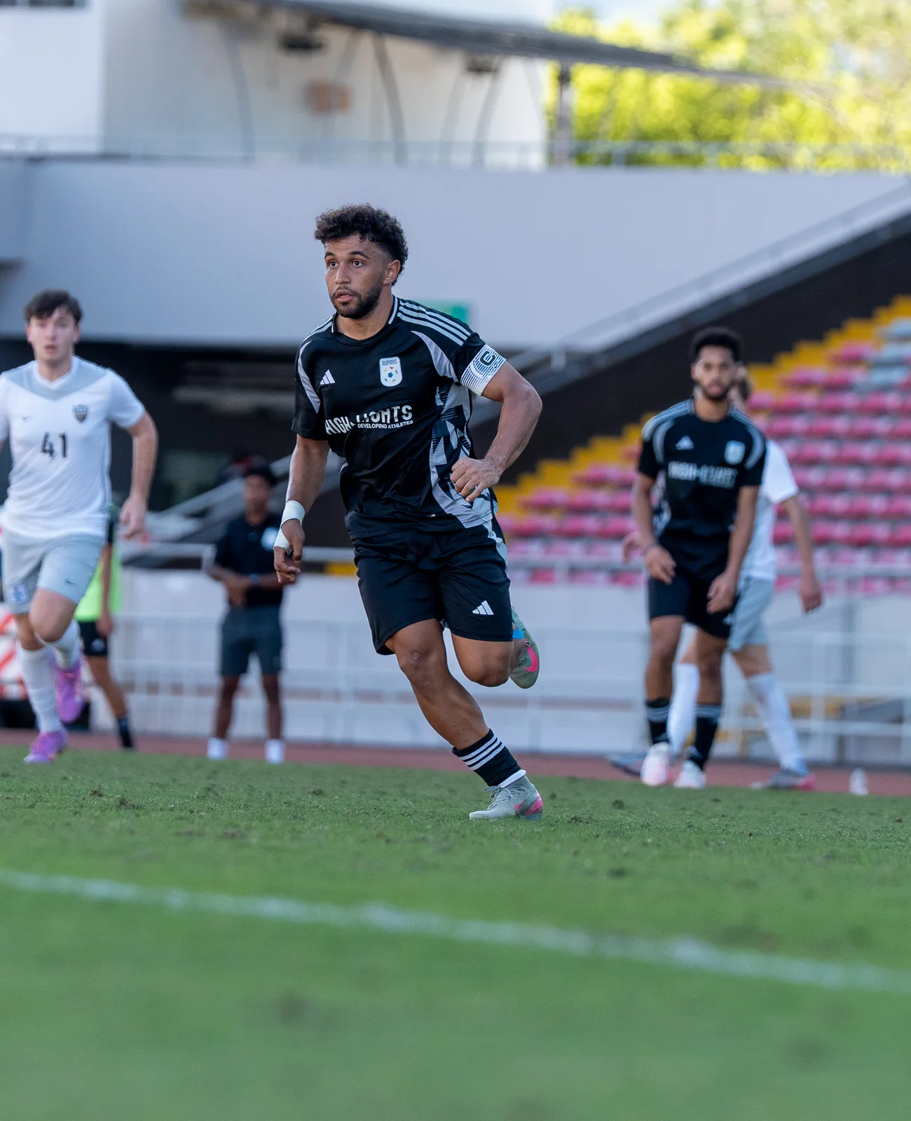 Highlights athlete moving forward during a stadium match