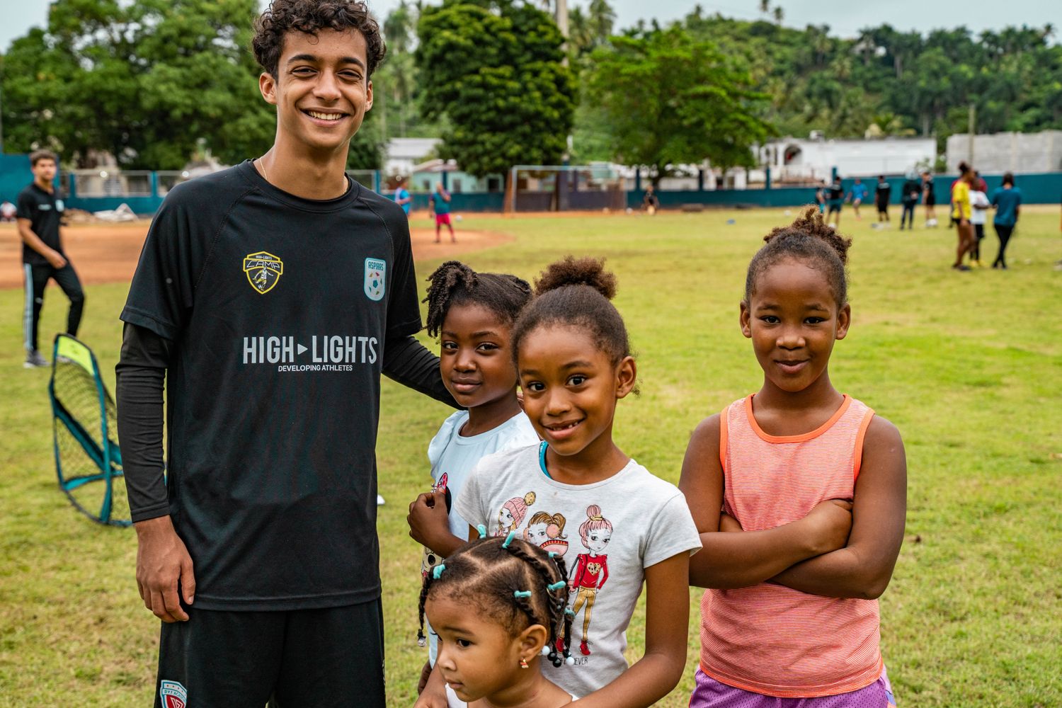 Highlights student-athlete spending time with children during a community service activity