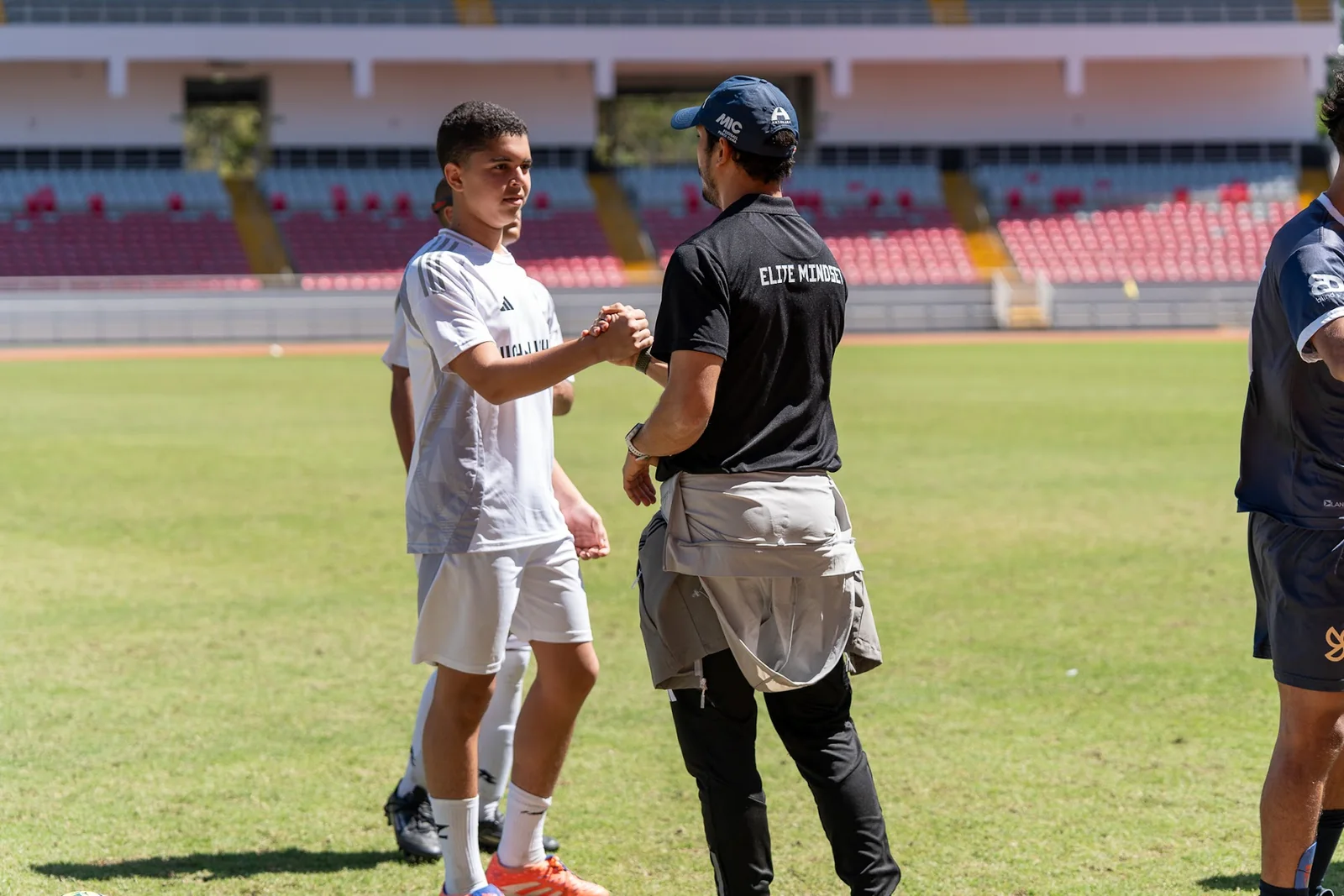 Coach greeting an athlete during a showcase on the field