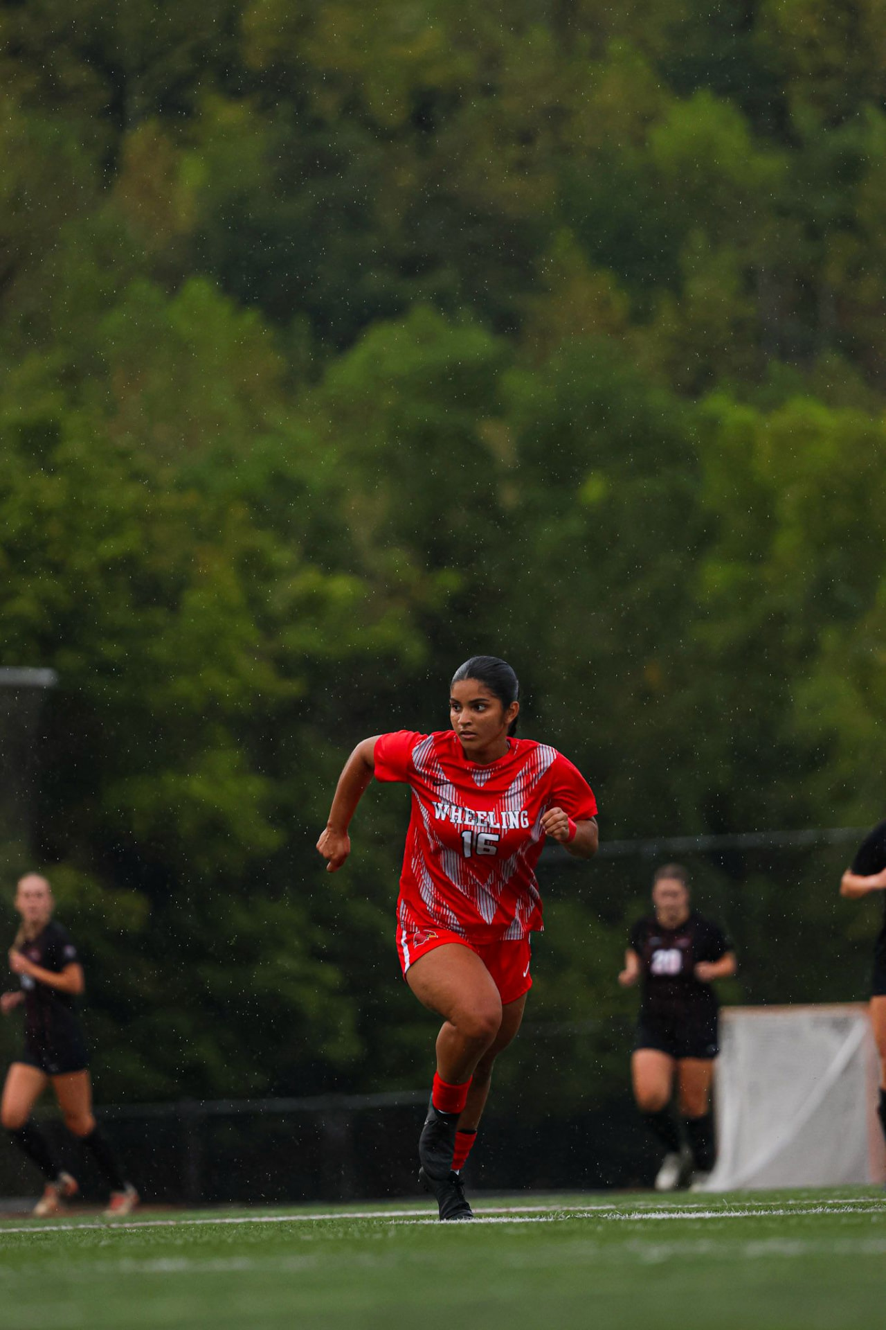 Jeanery Diaz playing college soccer for Wheeling University in the rain