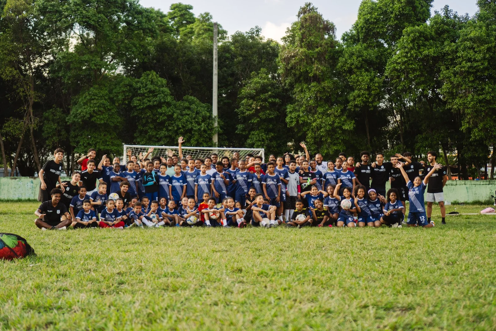 Large group of athletes and children gathered on a community soccer field