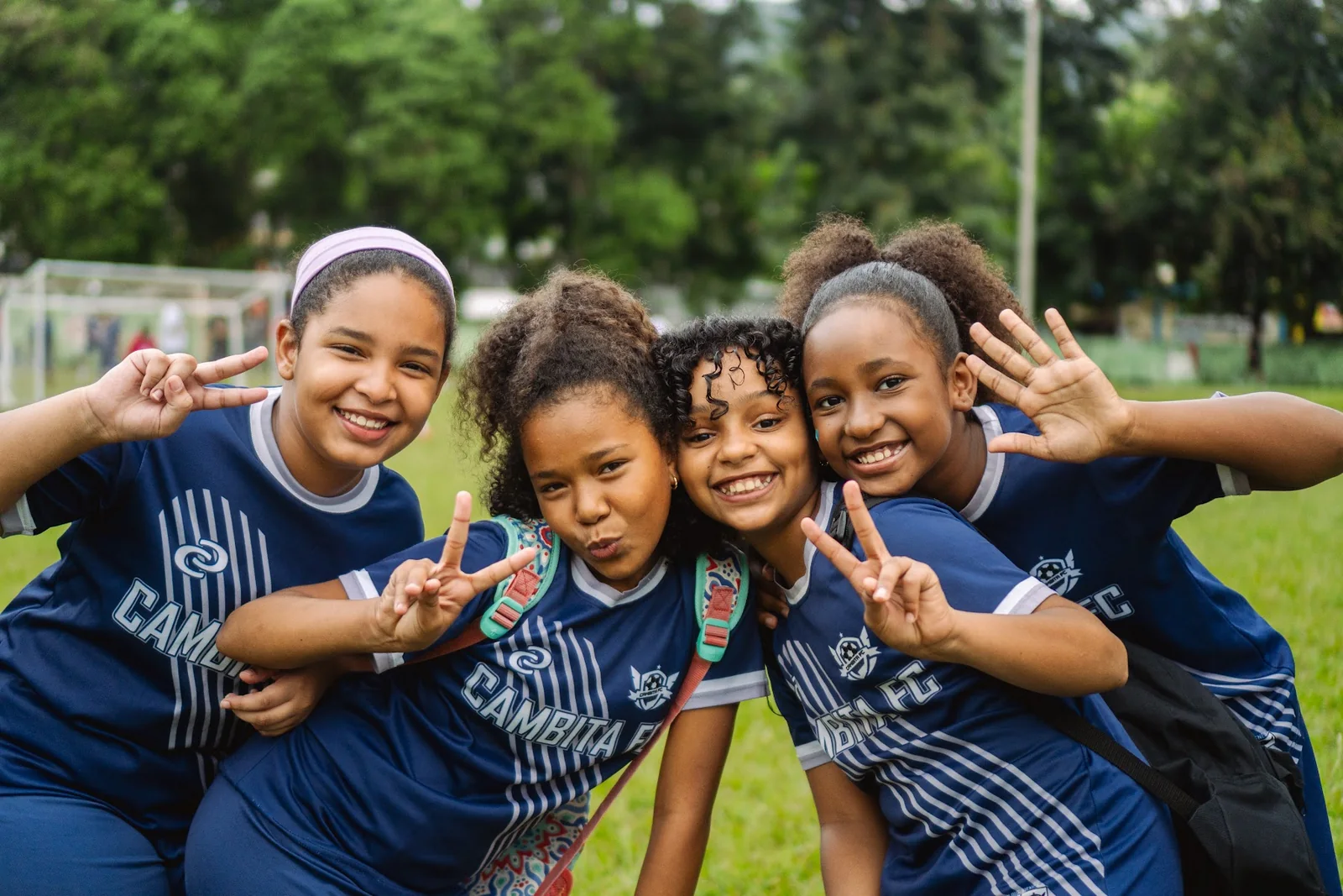 Group of girls smiling together during a community soccer clinic