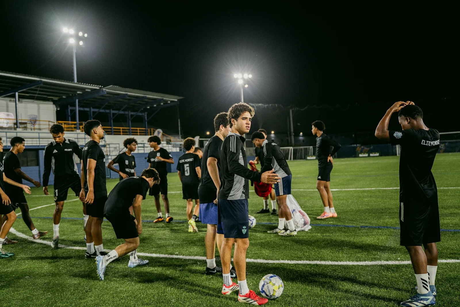 5AM Club athletes preparing together under stadium lights