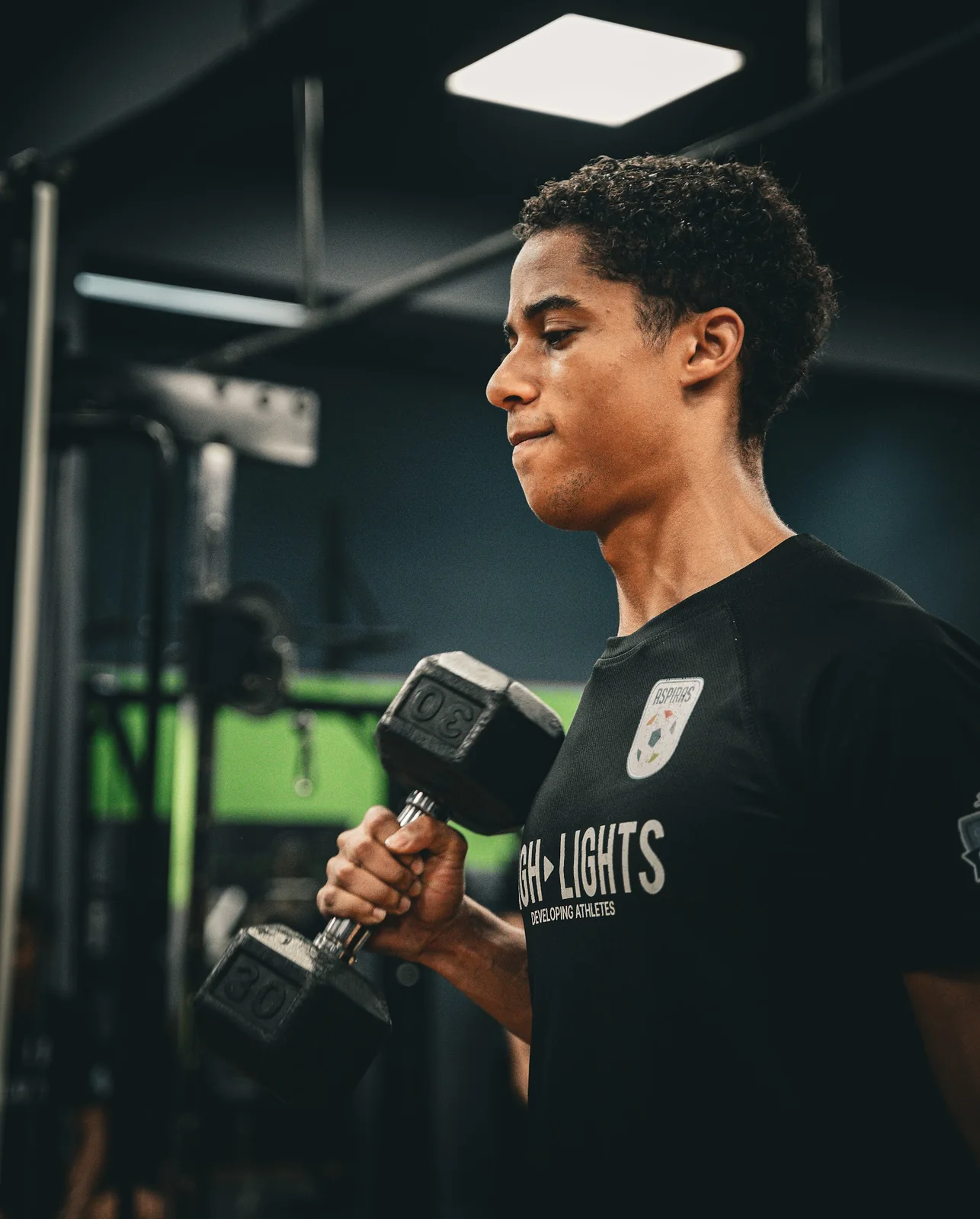 5AM Club athlete completing a dumbbell strength exercise in the gym